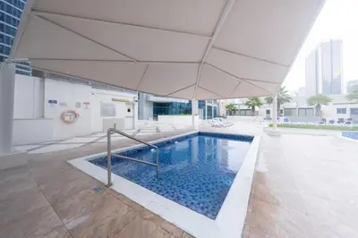 a swimming pool with an umbrella in a building at Charming Stay by Dubai Marina in Dubai