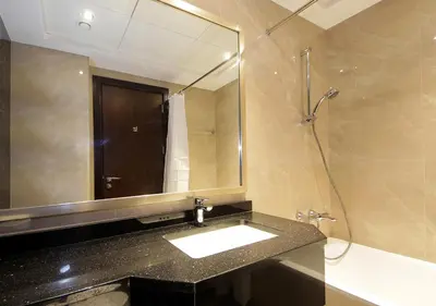 a bathroom with a sink and a mirror and a shower at Breathtaking Views from a H-Floor Studio in Dubai in Dubai