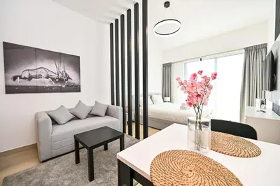a living room with a couch and a table at Chic Studio in Prime JVC Spot - Holiday Boulevard in Dubai