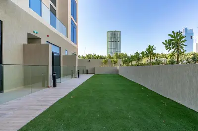 a courtyard in a building with a green lawn at Chic Studio in Prime JVC Spot - Holiday Boulevard in Dubai