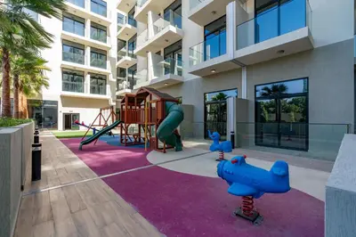 a playground in front of a building with a slide at Chic Studio in Prime JVC Spot - Holiday Boulevard in Dubai