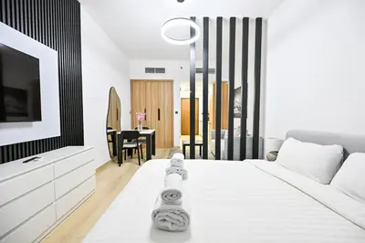 a bedroom with a white bed and a tv at Chic Studio in Prime JVC Spot - Holiday Boulevard in Dubai