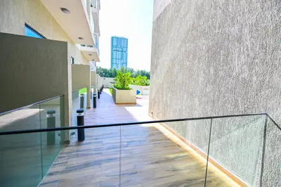 an empty hallway of a building with a glass railing at Modern Studio with Balcony and Pool Access - Holiday Boulevard in Dubai