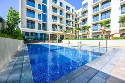 an image of a swimming pool in front of a building at Modern Studio with Balcony and Pool Access - Holiday Boulevard in Dubai