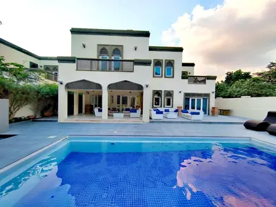 a villa with a swimming pool in front of a house at Signature 7-bedroom Villa Marina in Dubai