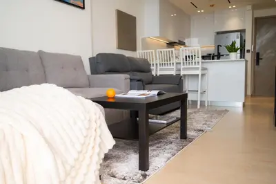 a living room with a couch and a table at Cozy NEW brand 1BR at JVC Binghatti Corner in Dubai