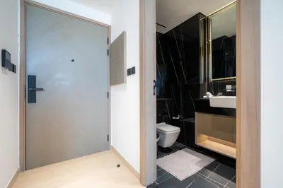 a bathroom with a toilet and a glass door at Cozy NEW brand 1BR at JVC Binghatti Corner in Dubai