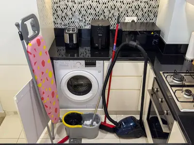 a small kitchen with a washing machine and a stove at Infinity Rooftop Pool with Full Burj Khalifa View in Dubai
