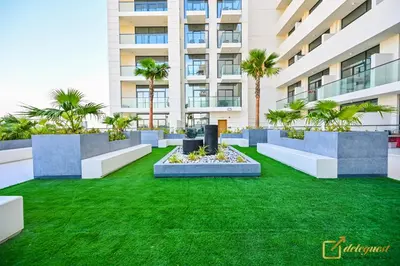 a building with a green lawn in front of a building at New Studio 5min Walk to Bus Stop in Dubai