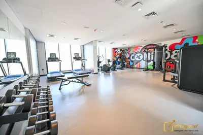 a gym with treadmills and machines in a room at New Studio 5min Walk to Bus Stop in Dubai