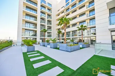 a courtyard in a building with palm trees at New Studio 5min Walk to Bus Stop in Dubai