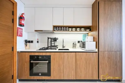 a kitchen with a stove and a microwave at New Studio 5min Walk to Bus Stop in Dubai