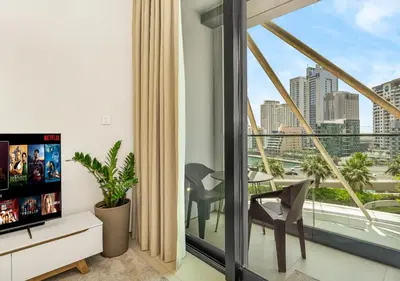a living room with a balcony with a view of the city at Cozy 1BR The Address JBR in Dubai