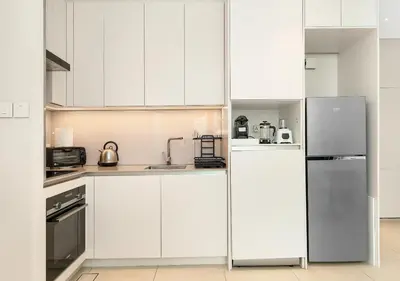 a kitchen with white cabinets and a refrigerator at Cozy 1BR The Address JBR in Dubai