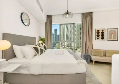 a bedroom with a large bed and a large window at Bay Central Modern Studio in Dubai