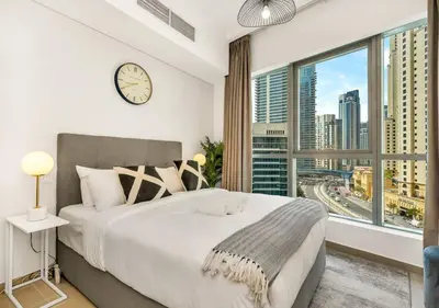 a bedroom with a large bed and a large window at Bay Central Modern Studio in Dubai