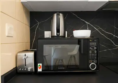 a microwave oven with a coffee pot on top of it at Bay Central Modern Studio in Dubai