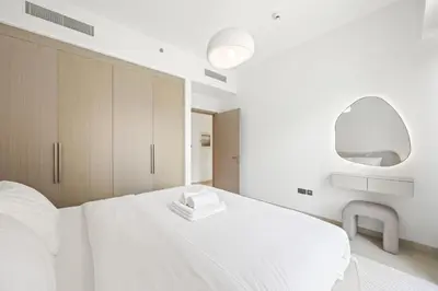 a bedroom with a white bed and a mirror at Act tower-1BR near burj khalifa in Dubai