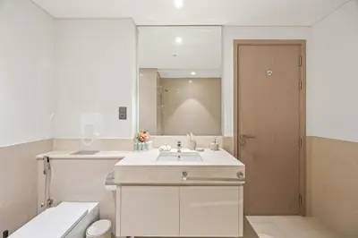 a white bathroom with a sink and a mirror at Act tower-1BR near burj khalifa in Dubai