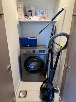 a washing machine with a mop next to a washer at Act tower-1BR near burj khalifa in Dubai