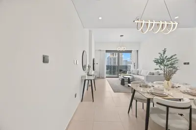 a white living room with a table and chairs at Act tower-1BR near burj khalifa in Dubai