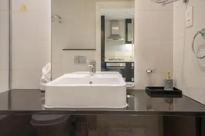 a white sink in a bathroom with a mirror at Cozy Canal View Studio in Dubai