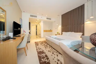 a hotel room with a large bed and a desk at Cozy Canal View Studio in Dubai