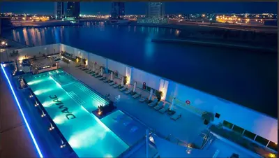 a swimming pool on a cruise ship at night at Cozy Canal View Studio in Dubai