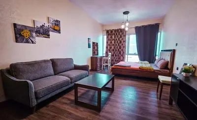 a living room with a couch and a table at Upgraded Studio In Dubai Marina in Dubai