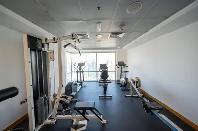 a gym with treadmills and machines in a room at Homes & Beyond l 2BR in the Heart of Dubai Marina in Dubai