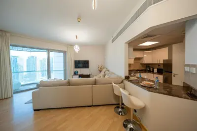 a living room with a couch and a kitchen at Homes & Beyond l 2BR in the Heart of Dubai Marina in Dubai