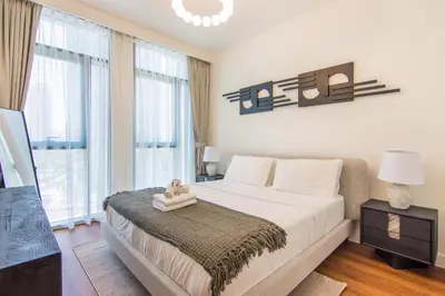 a bedroom with a large bed and a large window at Brand New Stylish 2 BR with Balcony in Dubai