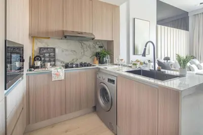 a kitchen with a sink and a washing machine at Frank Porter - Bali Residences in Dubai