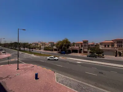 a white car driving down a city street at Frank Porter - Bali Residences in Dubai