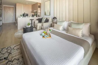 a large white bed in a living room at Frank Porter - Bali Residences in Dubai