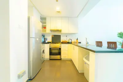 a kitchen with white cabinets and a refrigerator at AWS Holiday Homes - Charming stay near Golf Course in Dubai