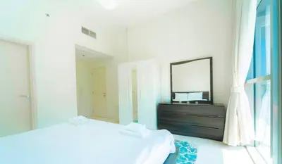 a bedroom with a bed and a mirror and a dresser at AWS Holiday Homes - Charming stay near Golf Course in Dubai