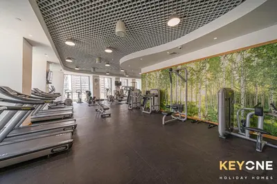 a gym with a bunch of treadmills and machines at Cayan Escape Lavish 1BR with Sea View in Dubai