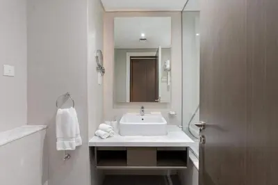 a white bathroom with a sink and a mirror at Luxury Canal-View Stay in Damac Privee in Dubai