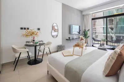 a bedroom with a bed and a table with chairs at Frank Porter - MYKA Residence in Dubai