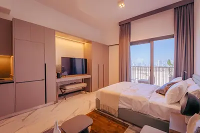 a bedroom with a large bed and a television at Voyage Studio In Mag City in Dubai