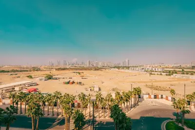 a large parking lot with palm trees and a city at Voyage Studio In Mag City in Dubai