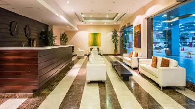 a lobby with white couches and a bar at Devine Homes JBR Hostel in Dubai