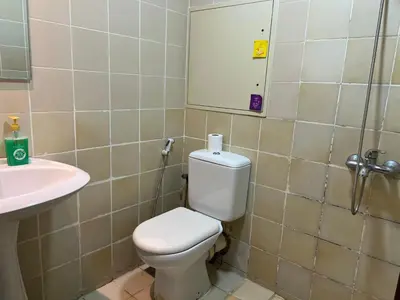 a bathroom with a toilet and a sink and a mirror at Devine Homes JBR Hostel in Dubai