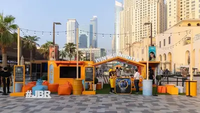 a market in a city with people standing around at Devine Homes JBR Hostel in Dubai