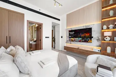 a living room with a white couch and a tv at Chic Studio with Balcony and Gym at JVC in Dubai