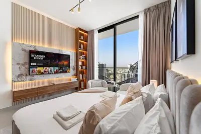 a hotel room with a bed and a flat screen tv at Chic Studio with Balcony and Gym at JVC in Dubai