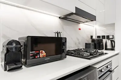 a microwave sitting on a counter next to a stove at Chic Studio with Balcony and Gym at JVC in Dubai