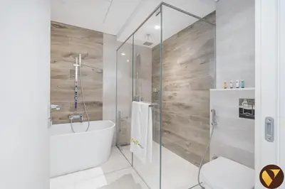 a bathroom with a shower with a tub and a toilet at Vogue JLT Banyan Tree Residences Hillside, near Marina and JBR, Two Bedroom Apartment with Balcony and City View, Access to all Amenities in Dubai