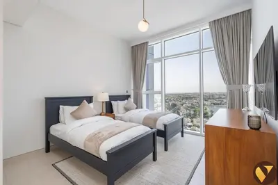 a bedroom with two beds and a large window at Vogue JLT Banyan Tree Residences Hillside, near Marina and JBR, Two Bedroom Apartment with Balcony and City View, Access to all Amenities in Dubai